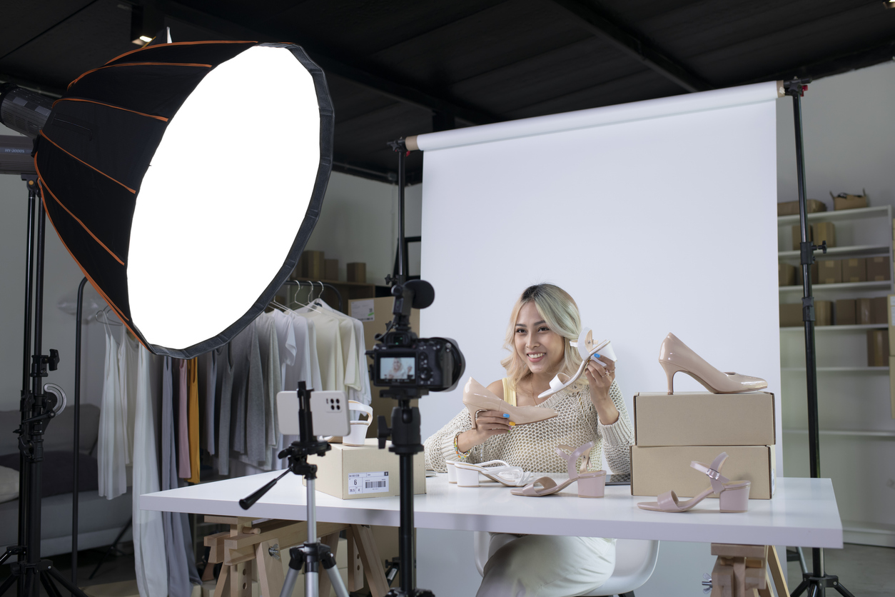 asian female blogger or vlogger looking at camera reviewing product.