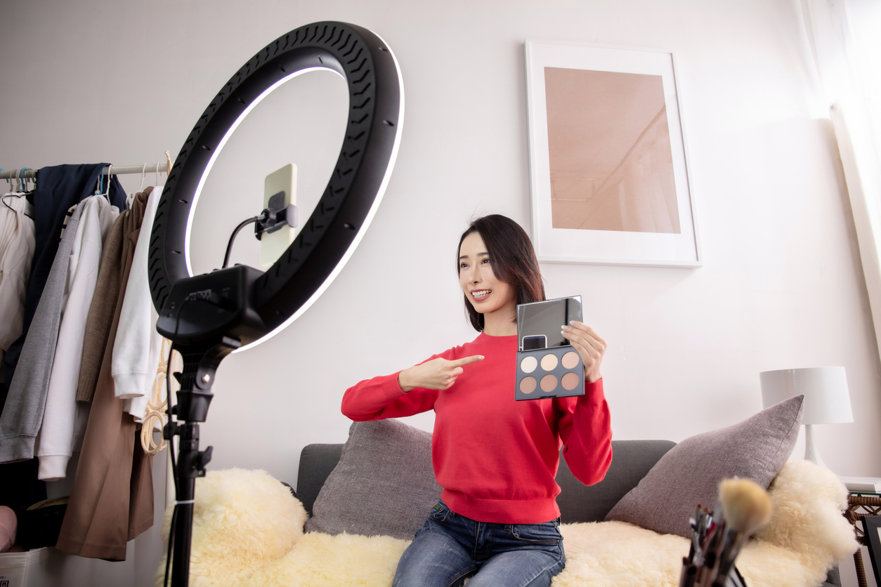 young asian woman live streaming to teaching make up online