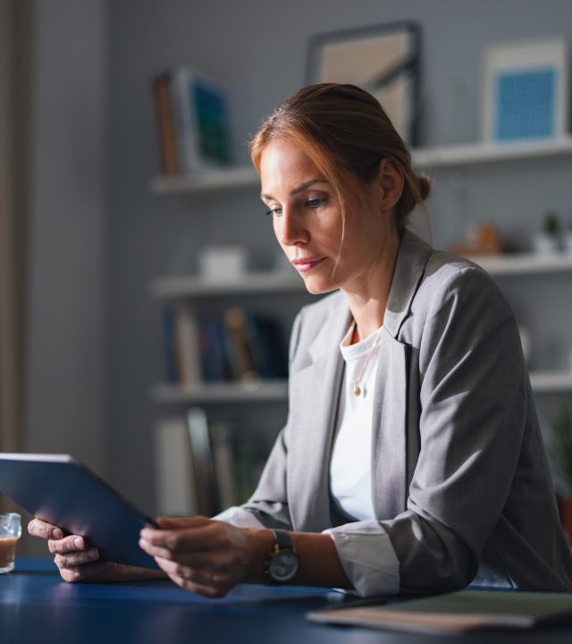 professional woman works at home office reading tablet in quiet study space